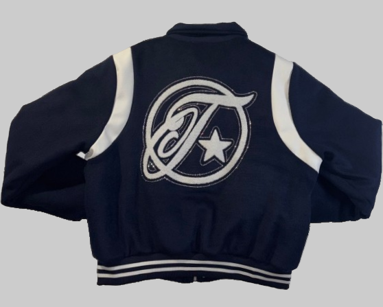 Navy blue varsity jacket with a logo on the back against a gray background