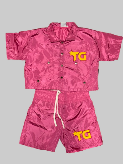 Pink jacket and shorts set with 'TG' logo on a white background