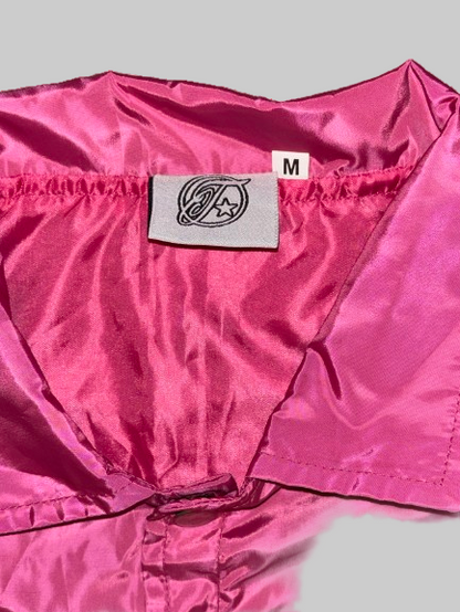 Close-up of a pink jacket with a brand label on a white background